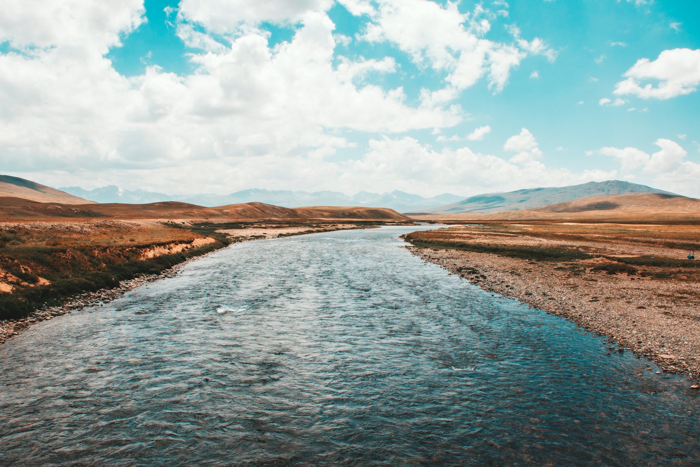 A winding river flows through an expansive arid landscape.